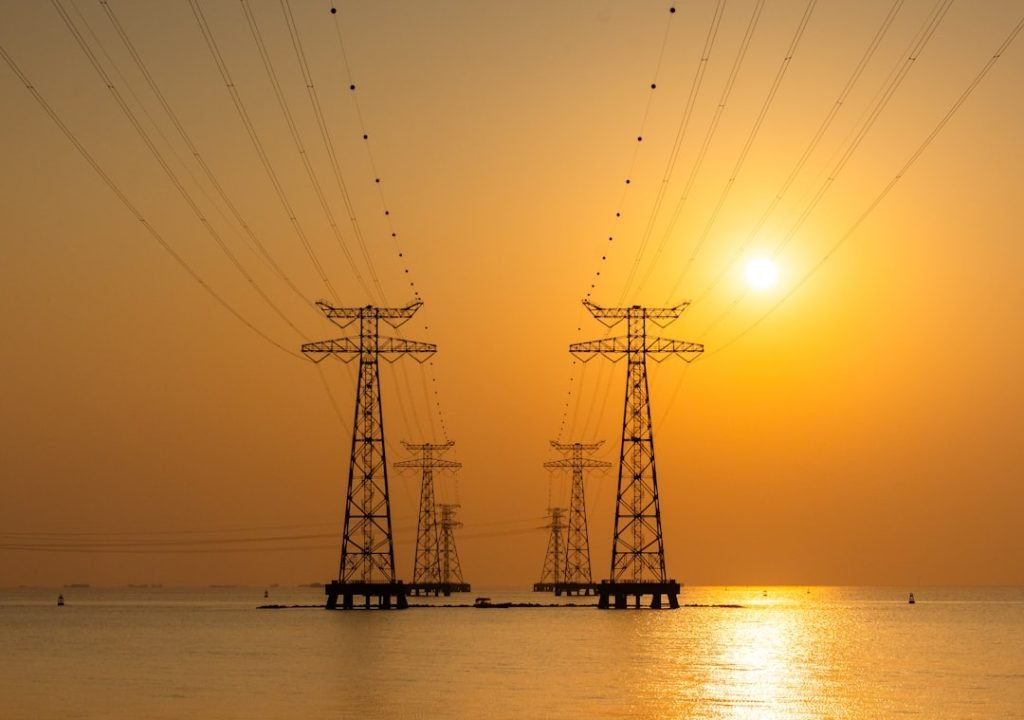the-sun-is-setting-over-the-water-and-power-lines-brztfads47q